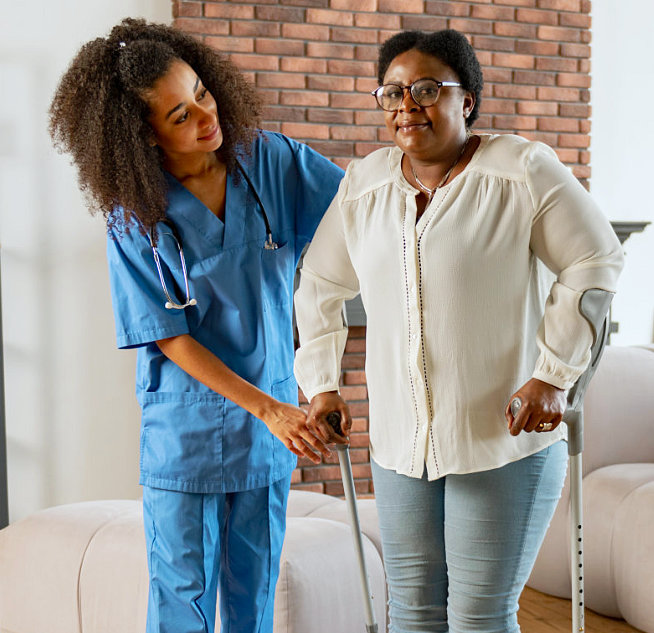 caregiver assisting senior woman to walk